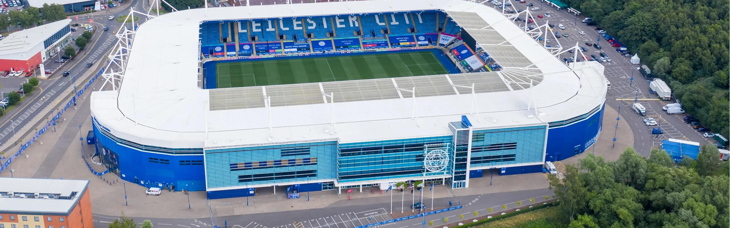 A luxury Manner Borne chauffeur car parked outside King Power Stadium, providing executive matchday transport for Leicester City fans.
