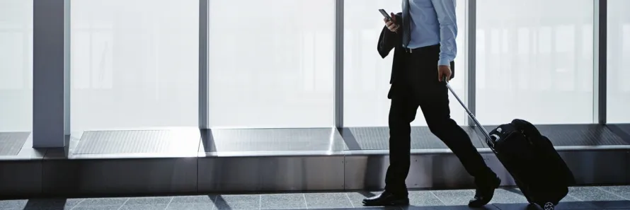 A professional Manner Borne driver providing a luxury Glasgow airport chauffeurs service with a pristine Mercedes-Benz executive vehicle at the terminal.