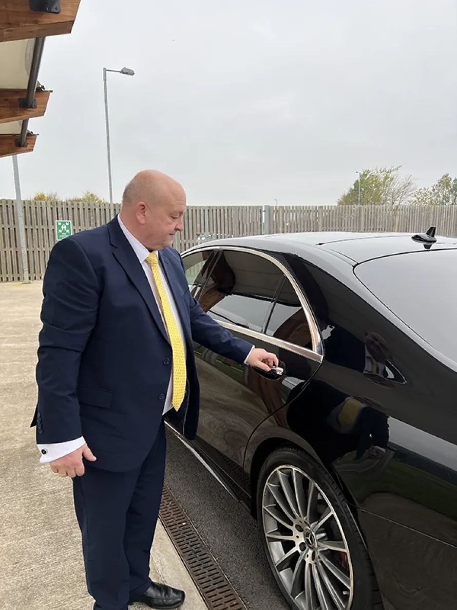 Professional business travel driver providing a luxury Accrington Chauffeur Service with a silver Mercedes S-Class for executive travel and special occasions. Chauffeur Service Manchester for VIP Clients